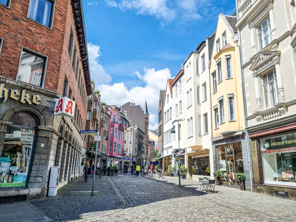 Altstadt von Aachen mit Kopfsteinpflaster und farbenfrohen Häusern zu beiden Seiten