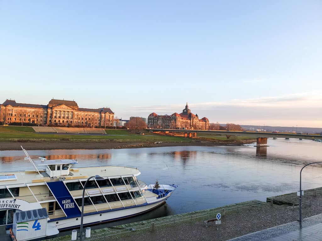 Dresden: Blick von der Brühlschen Terrasse über die Elbe am Morgen - links historische Gebäude, im Vordergrund eine Fähre