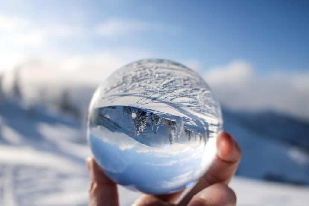 Glaskugel in der sich eine Schneelandschaft spiegelt