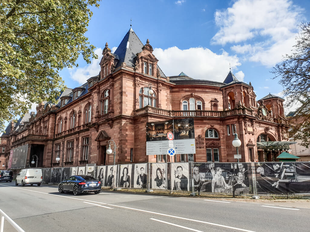 imposanter Bau aus rotem Stein mit vielen Türmchen und großen Fenstern - Kongresshaus Heidelberg