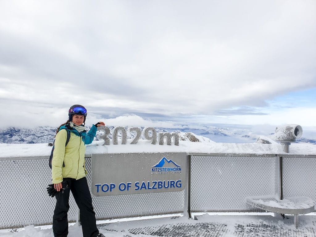 Frau steht auf einer Aussichtsplattform mit Blick auf Berggipfel