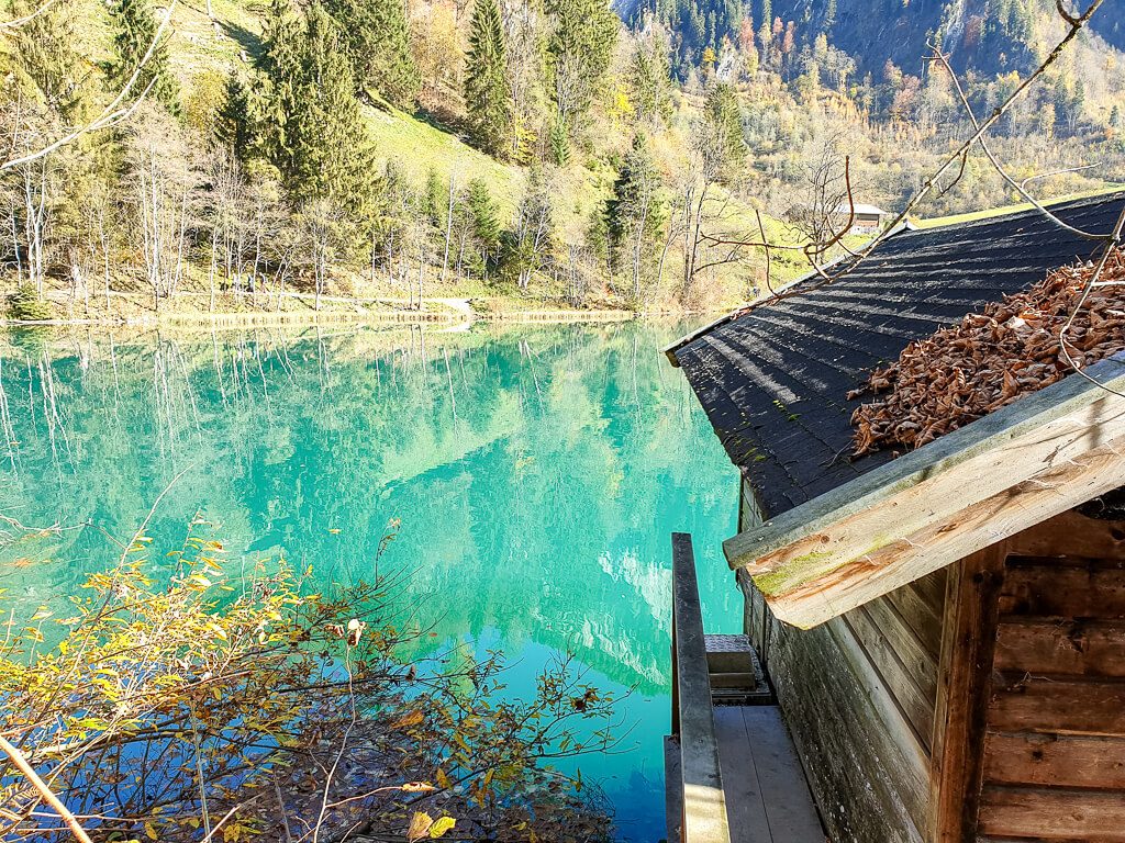 Berghütte mit Blick auf einen türkis-grünen See