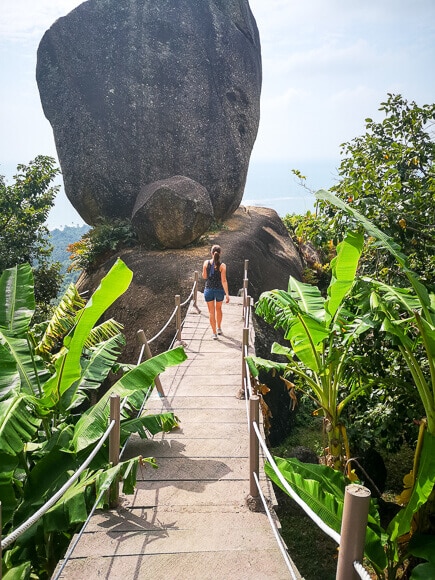Ko Samui - Overlap Stone - Frau geht über eine Hängebrücke zu einem riesigen Felsen hinüber
