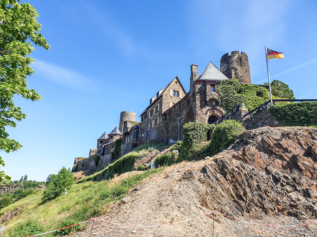 Burganlage mit mehreren Türmen auf einem Hügel im Grünen