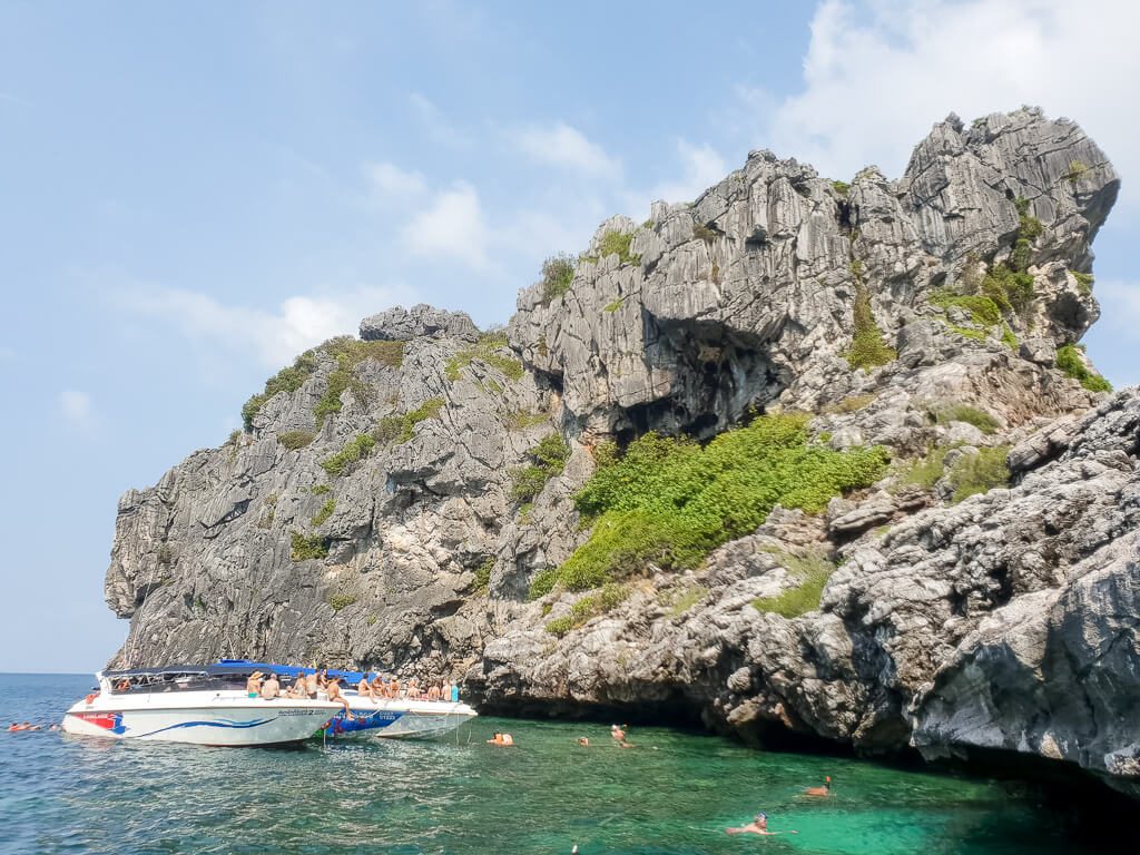 Boot liegt an einer kleinen Insel aus Felsen im Meer