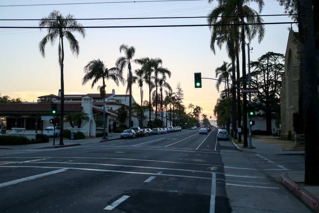Sonnenuntergang über einer mit Palmen gesäumten Straße