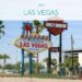 Bild zeigt das Las Vegas Sign von vorne auf dem Mittelstreifen einer Fahrbahn. Oben über dem Bild liegt ein helles Overlay mit Text "USA - Las Vegas"