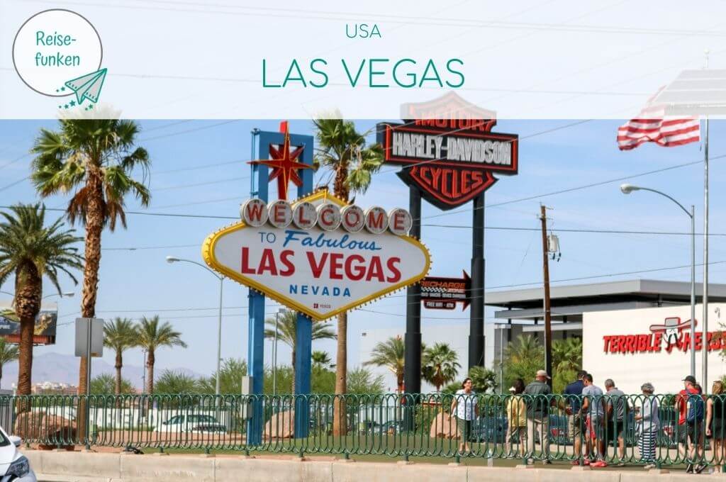 Bild zeigt das Las Vegas Sign von vorne auf dem Mittelstreifen einer Fahrbahn. Oben über dem Bild liegt ein helles Overlay mit Text "USA - Las Vegas"