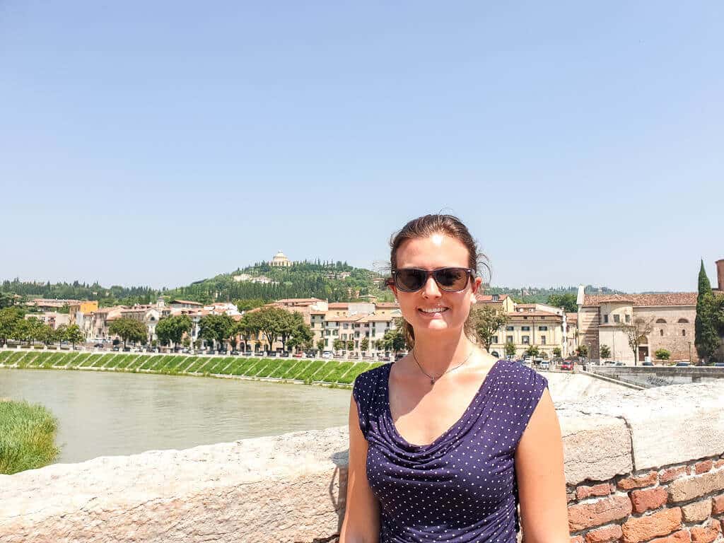 Frau steht auf Brücke - Fluss im Hintergrund