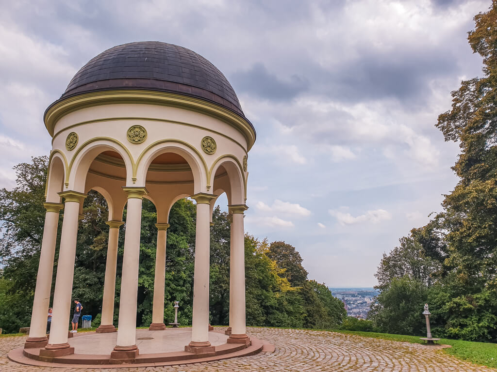 hell getünchter Pavillon mit Säulen und Ausblick über Wälder auf die Stadt Wiesbaden